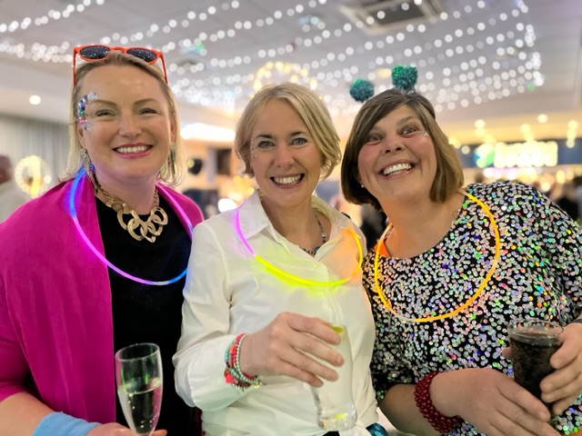 Three ladies with glitter and gems on their faces at a party in Shrewsbury
