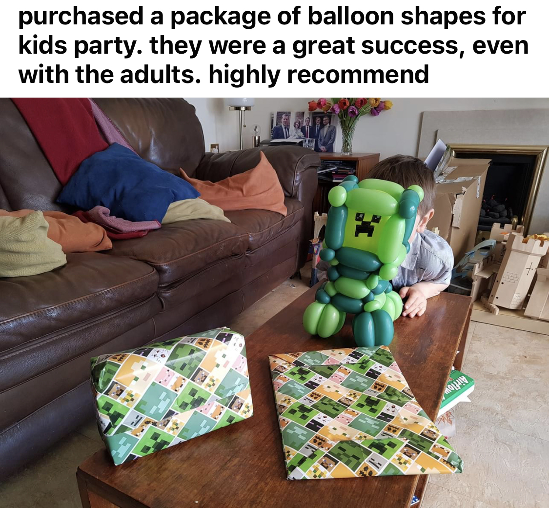 Child holding a minecraft balloon with a minecraft present for his birthday