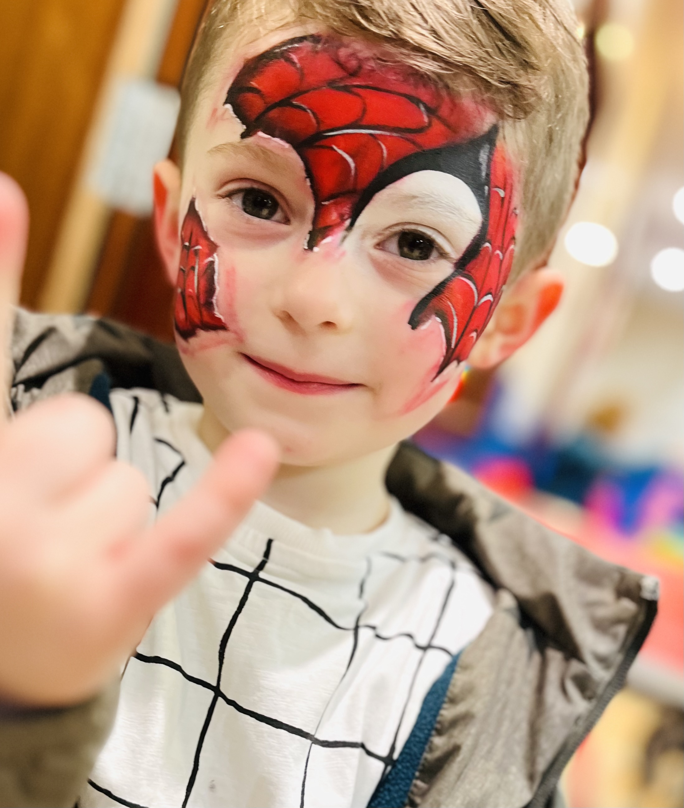 boy with his face painted like spiderman