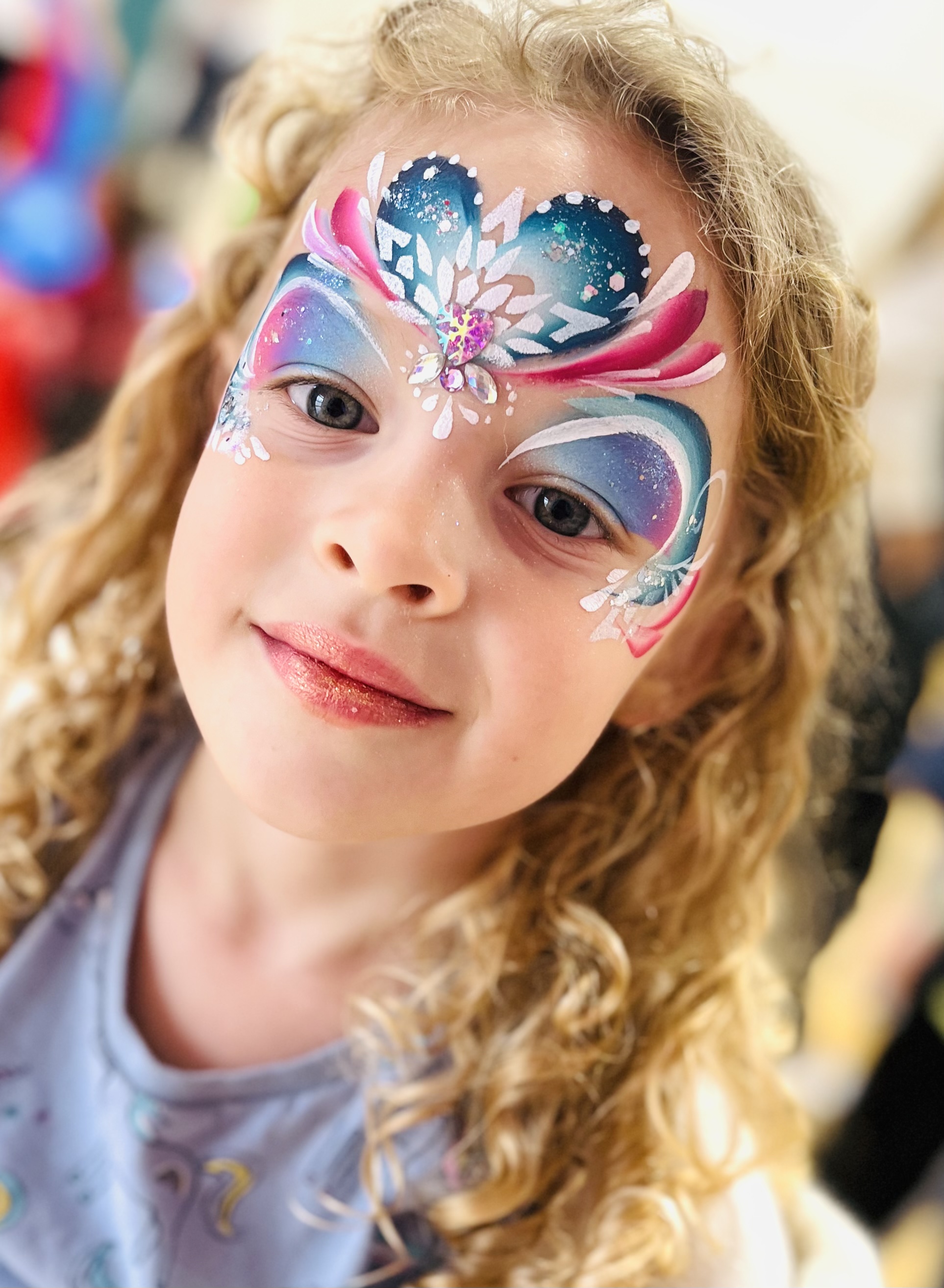 girl with face painted like Elsa with gems