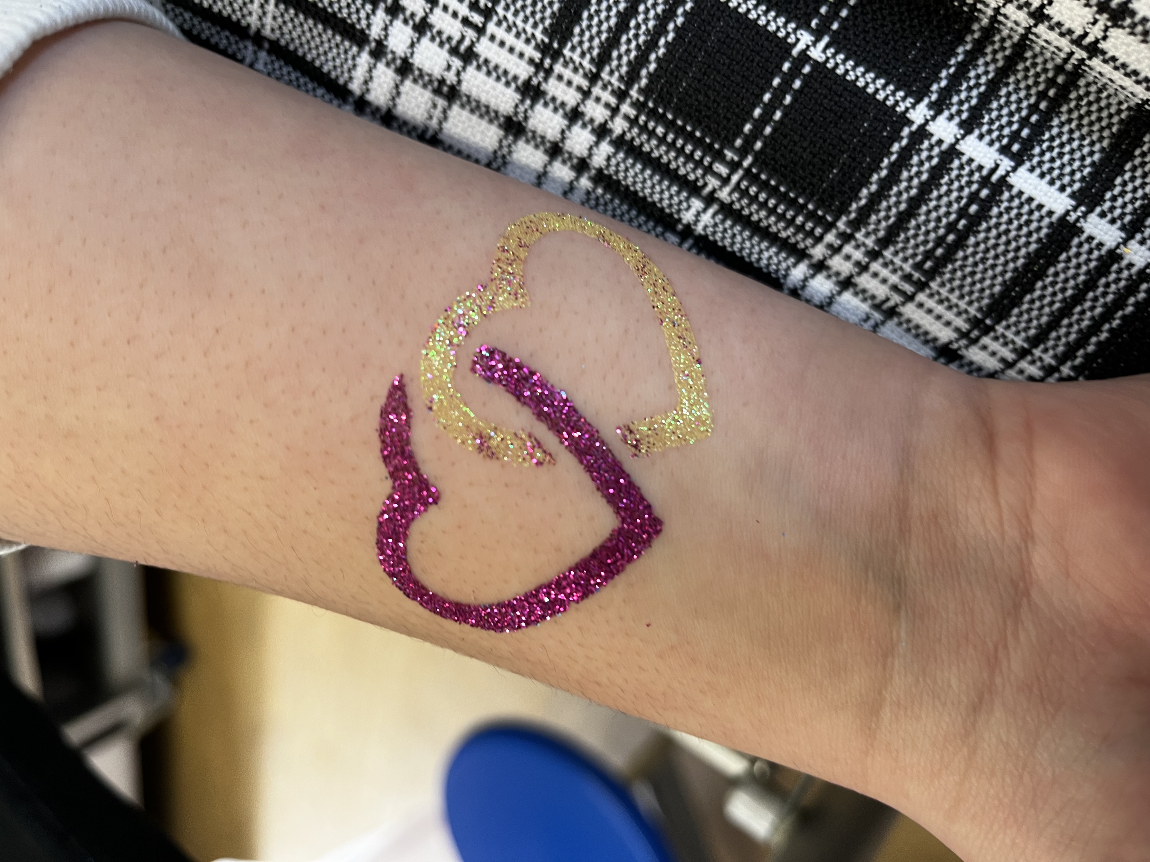 Hearts glitter tattoo on girls arm in telford
