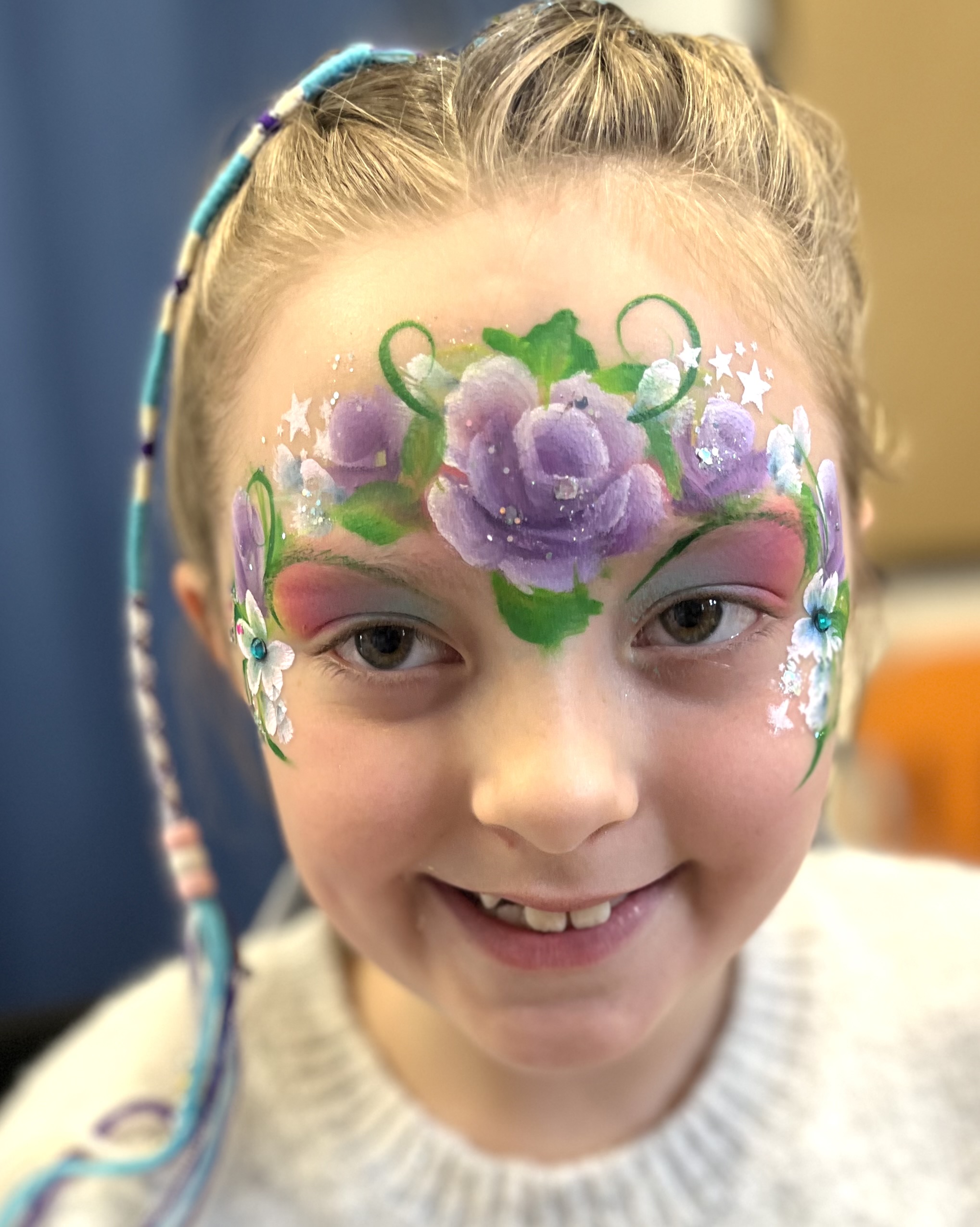 Purple roses face paint on young girls face