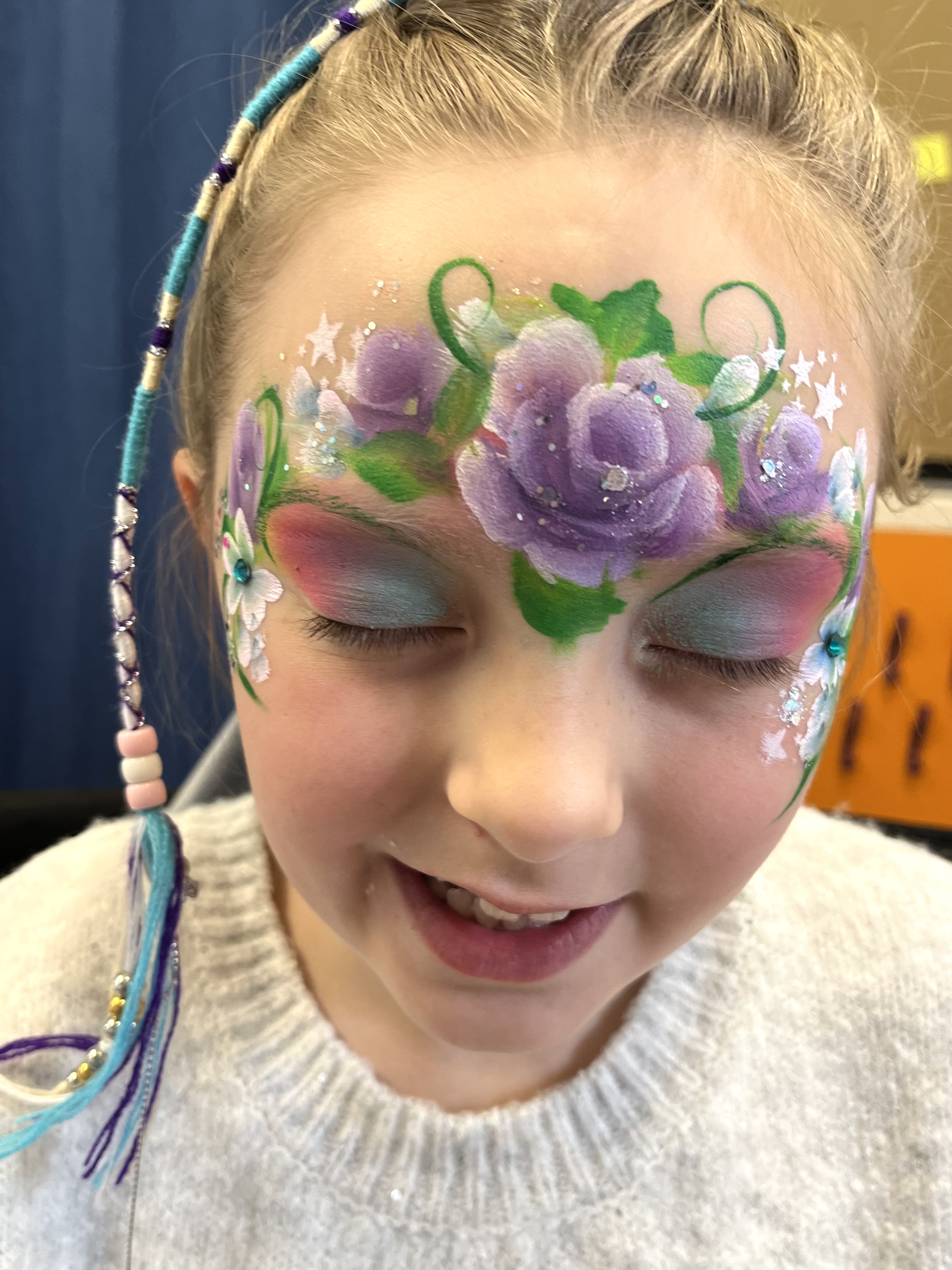 Purple roses face painting on young girl in Telford