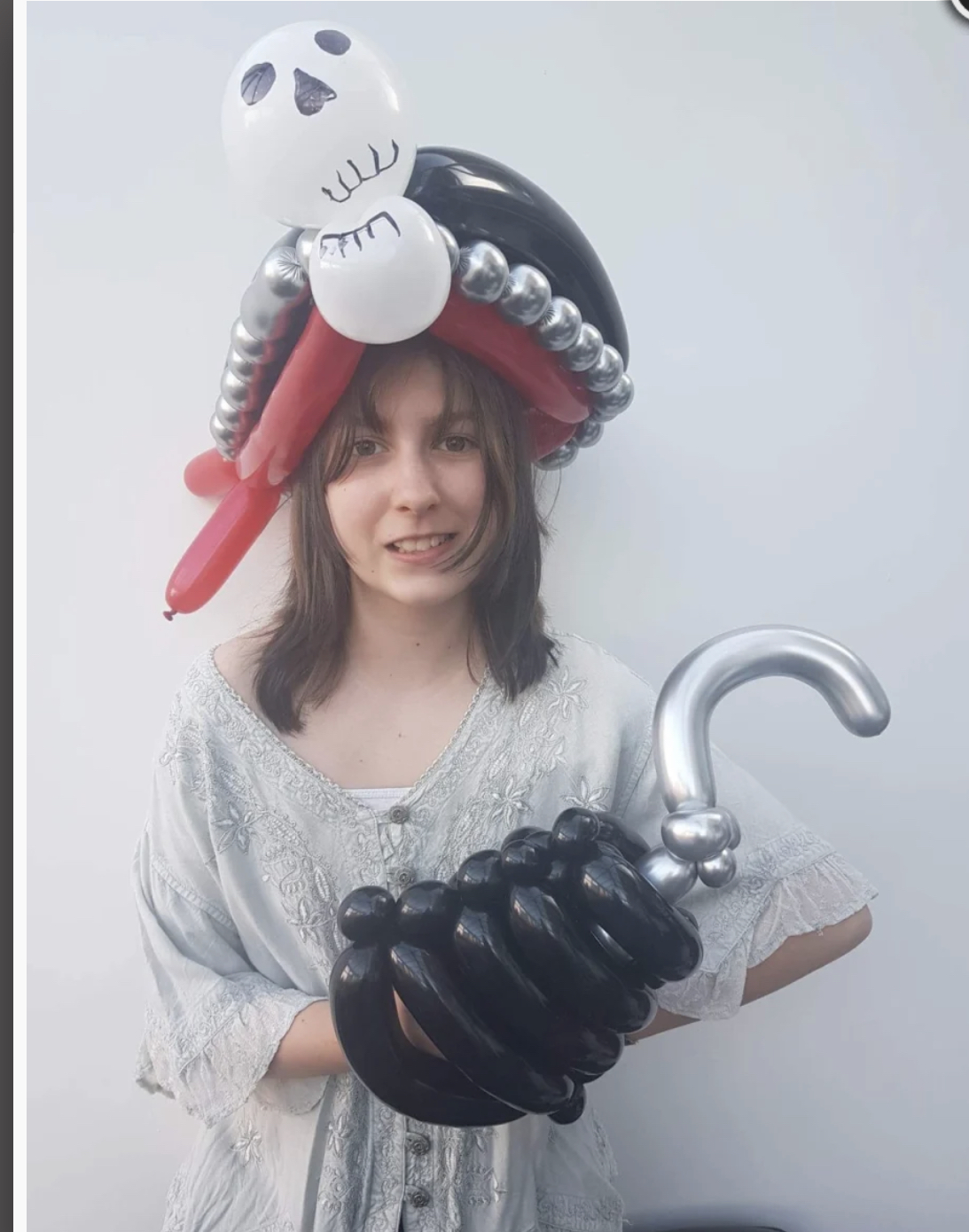 Girl wearing pirate costume ball from balloons for world book day