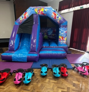 Blue bouncy castle with slide at a party in Telford
