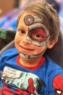 Boy with robot face paint at a party in Telford
